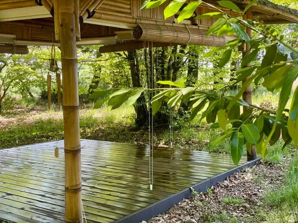 La paillote balinaise du domaine de Sallebœuf : un plancher de bois sous un toit de bambou, au cœur du sous-bois.